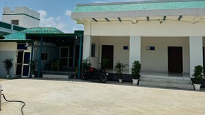 A building with a covered entrance, potted plants, and a clear sky.