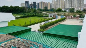 A residential area with high-rise buildings in the background, a green lawn, and a construction site.