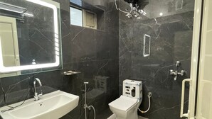 A modern bathroom with a white sink, a toilet, and a shower area.
