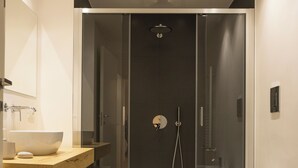 A modern bathroom with a glass-enclosed shower, a freestanding bathtub, and a vanity with a bowl sink. - Luxury Freedom Minerva (Palermo)