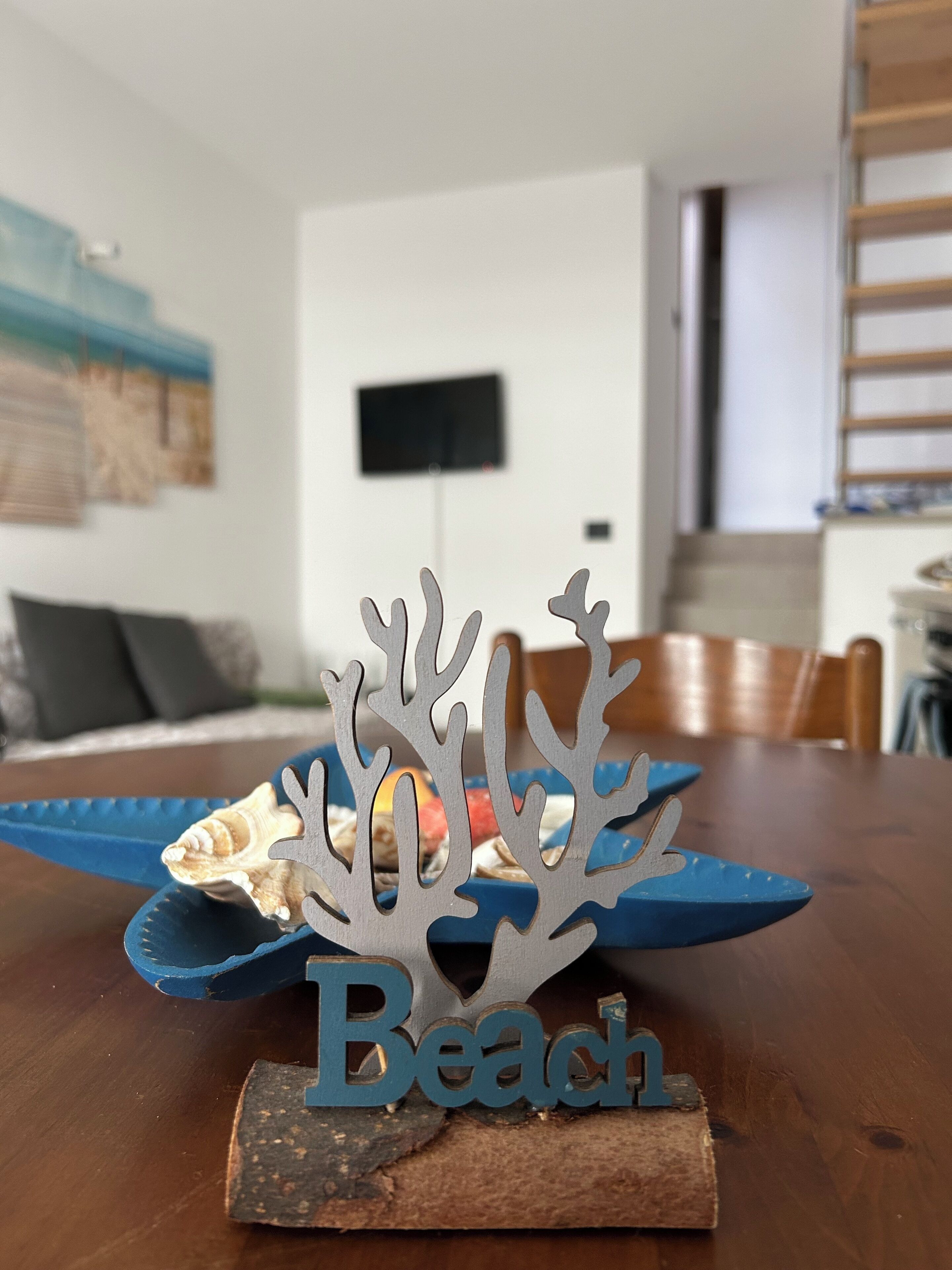 A wooden table with a decorative piece labeled "Beach" and a seashell.