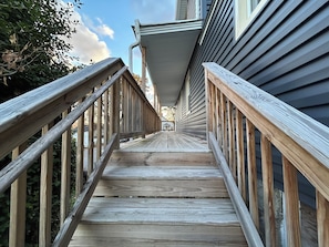 Eine Holztreppe führt zu einem Haus mit einer Veranda.