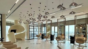 Eine moderne Hotelhalle mit großzügigem Design, mehreren Sitzbereichen und Blick auf die Stadt durch große Fenster.