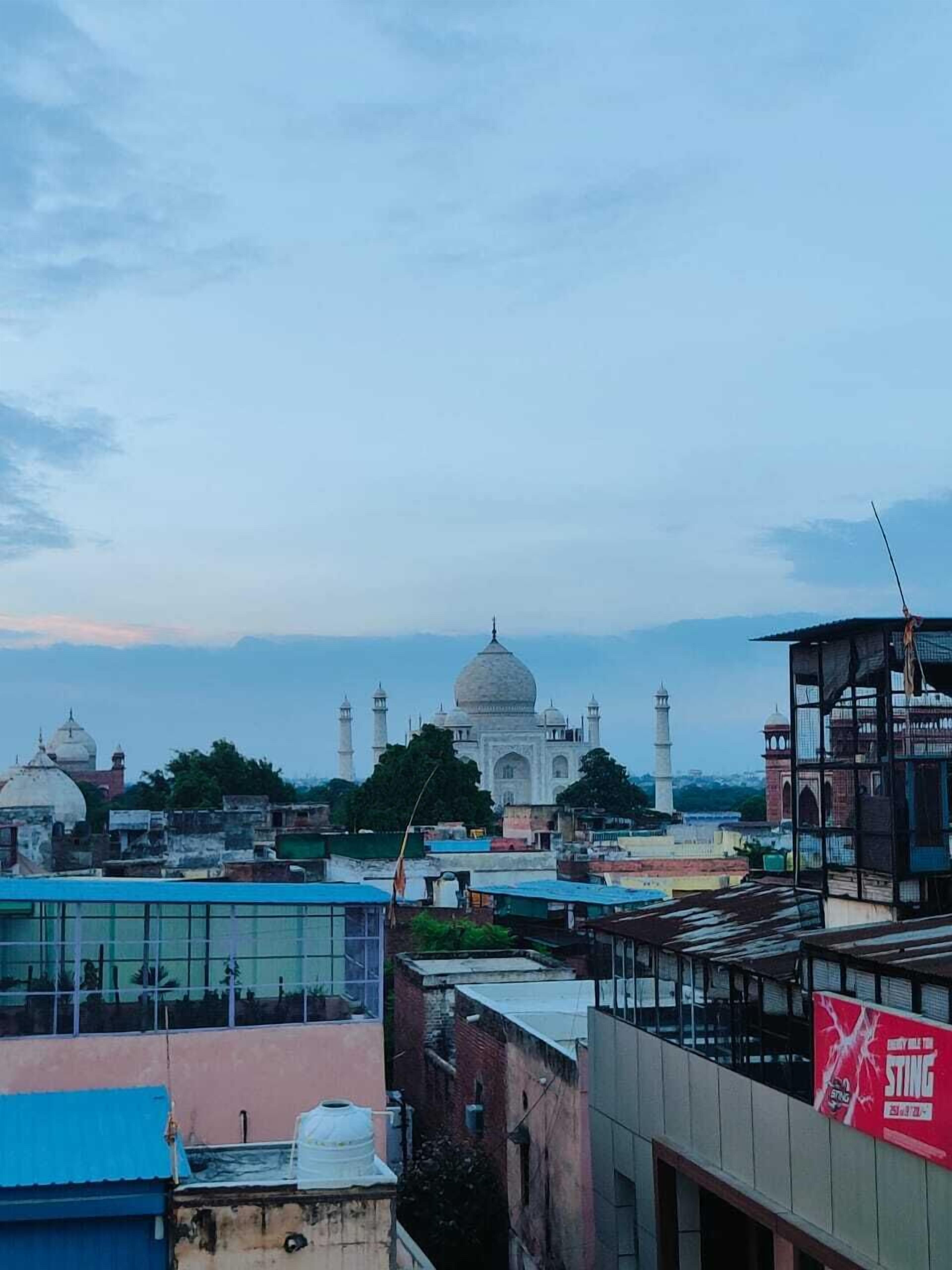 Vista del Taj Mahal con edificios circundantes y cielo despejado.