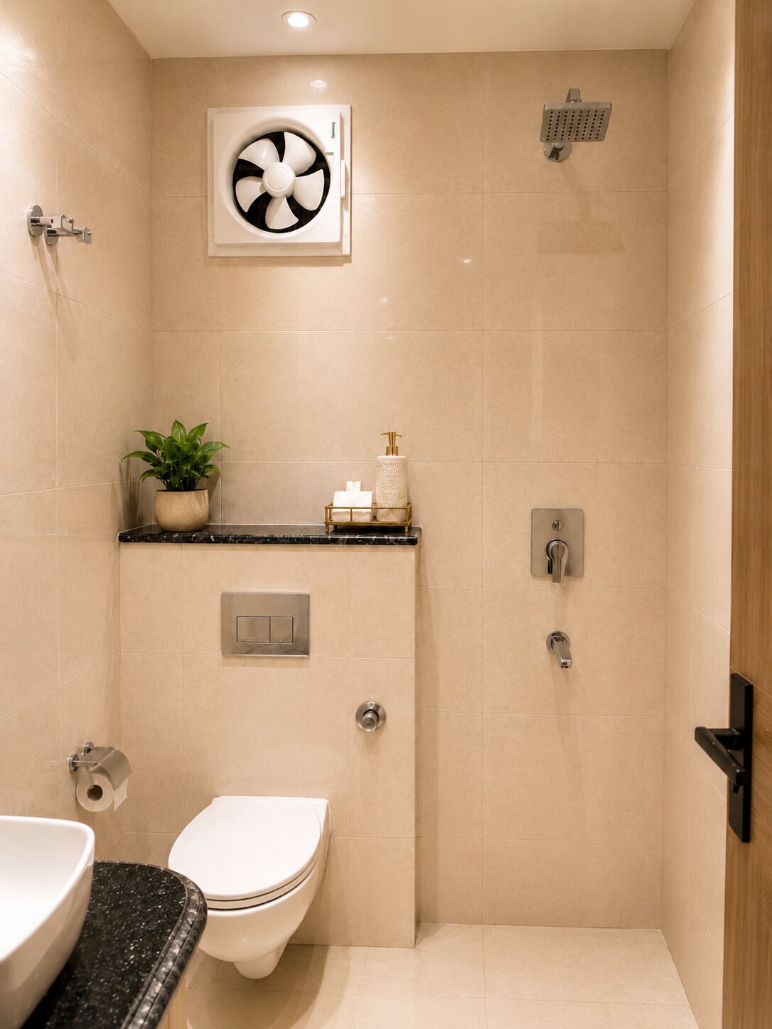 Et badeværelse med toilet, håndvask, bruser og en ventilator.