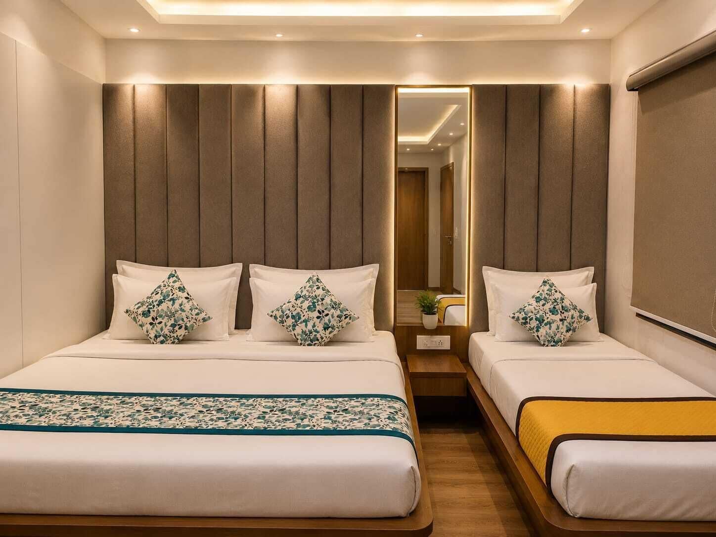Een hotelkamer met een groot bed, twee nachtkastjes, een spiegel en een hoofdbord met verticale panelen.