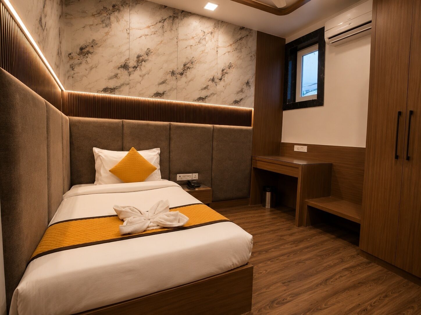 A hotel room with a bed, a desk, and a wardrobe.