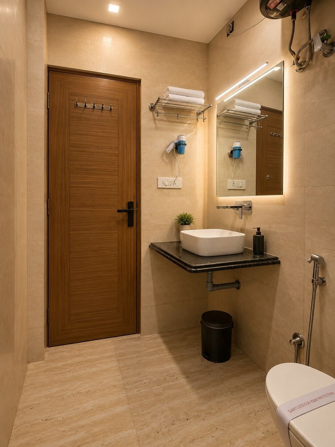 Un baño moderno con puerta de madera, un lavamanos con espejo, un perchero para toallas y una ducha.