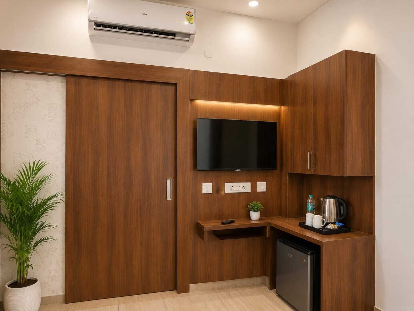 A compact kitchenette with a built-in TV, a small countertop, and a coffee maker.