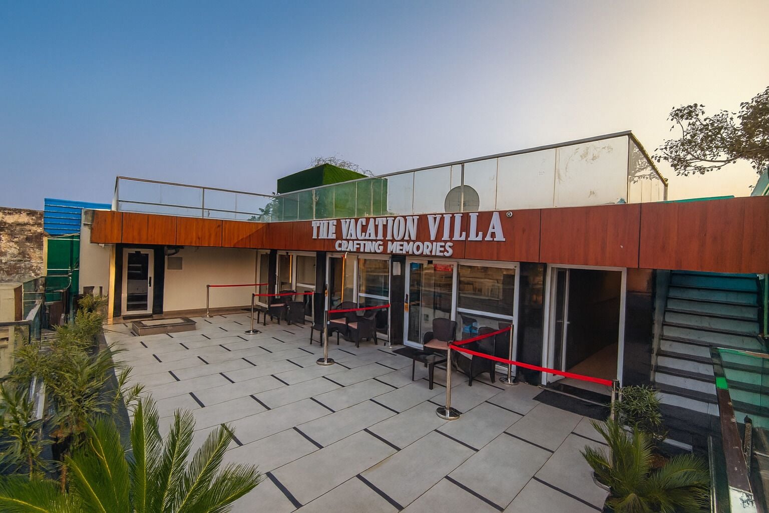 Un edificio llamado "The Vacation Villa Crafting Memories" con asientos al aire libre y una escalera.