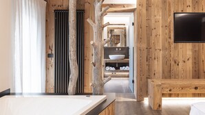 Une salle de bain moderne avec un intérieur en bois, un grand miroir, une baignoire et un meuble-lavabo.