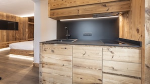Une cuisine de taille réduite, dotée de meubles en bois et d’une cuisinière intégrée.