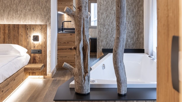 Une chambre à coucher moderne avec un plafond en bois, une grande fenêtre et une baignoire.