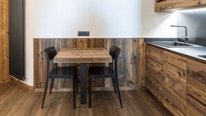 Eine moderne Küche mit Holztisch und -stühlen, einer eingebauten Spüle und einem Holzschrank.