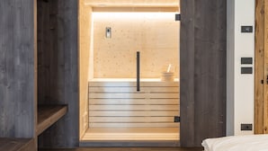 A sauna room with wooden walls and a bench.