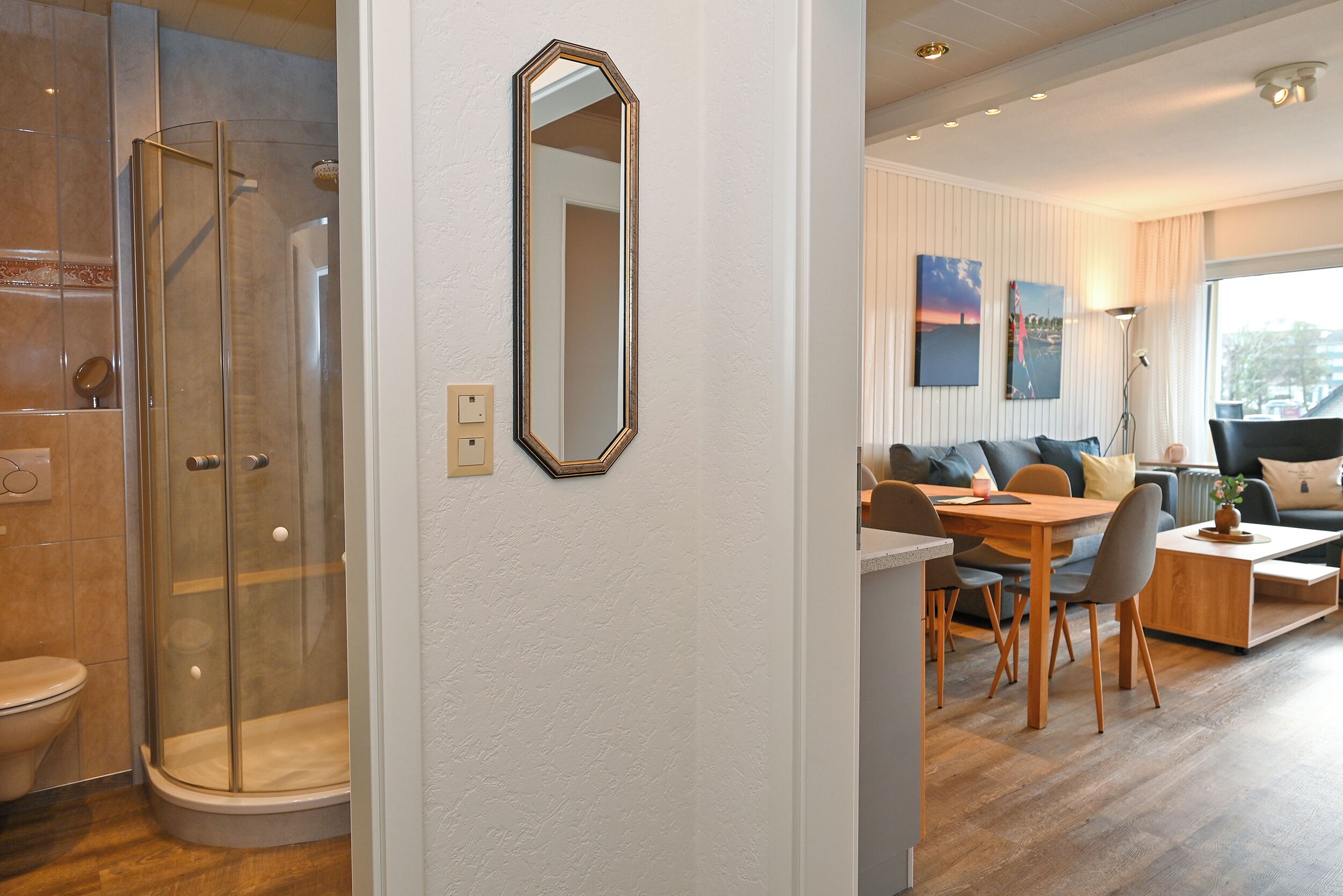A modern bathroom with a glass shower enclosure, a toilet, and a mirror on the wall.