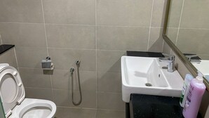 Un baño con inodoro, ducha y lavamanos.