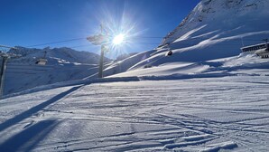 Un telesilla bajo un cielo despejado y laderas cubiertas de nieve.