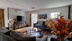 Un salon moderne avec un canapé, une table basse et un téléviseur.