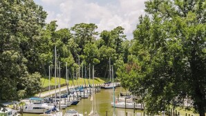 A marina with boats docked, surrounded by lush greenery and trees. - Fly Creek Collection - Bluff View (Fairhope)