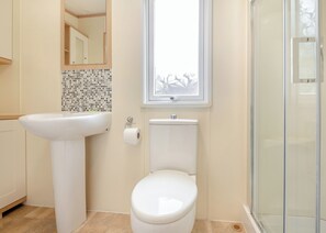 A bathroom with a sink, toilet, and a window. - 2 bedroom accommodation in Bala, (Bala,)