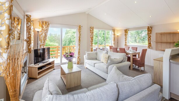 Een ruime woonkamer met een bank, televisie en eethoek.