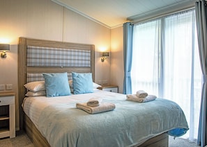 A hotel room with a bed, two bedside tables, a headboard, and a window with curtains. - 2 bedroom accommodation in Bala, (Bala,)