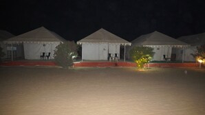 A row of white tents with tables and chairs, set against a dark night sky. - Raj Dunes Resort (Jaisalmer)
