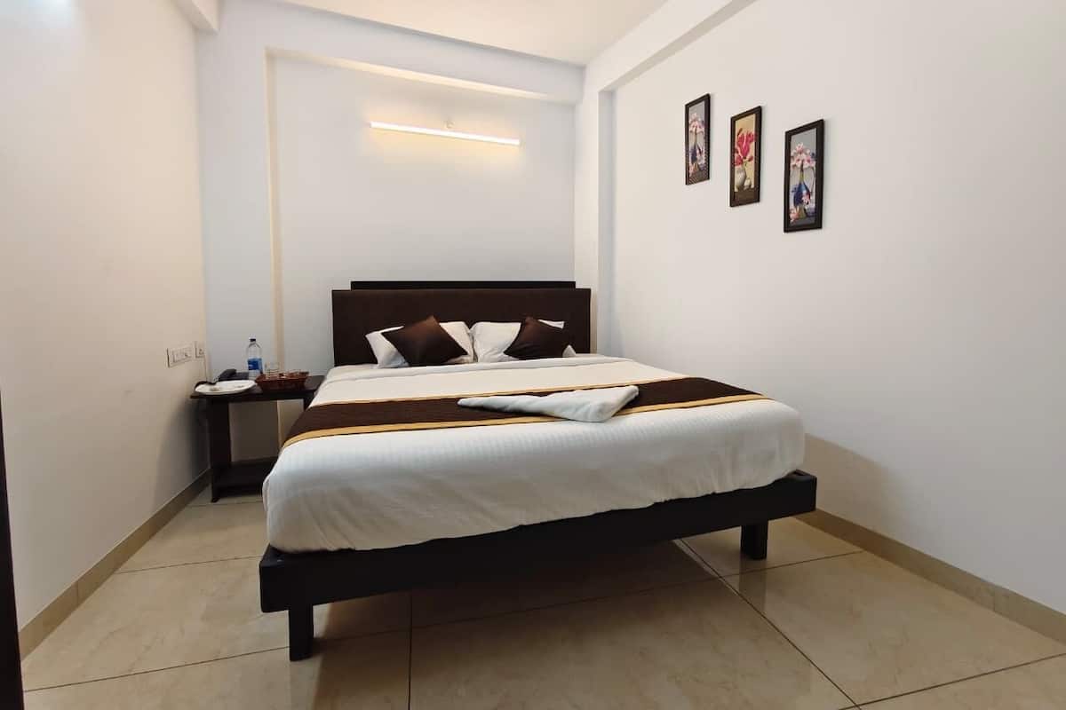 A neatly arranged hotel room with a bed, bedside table, and wall-mounted artwork.