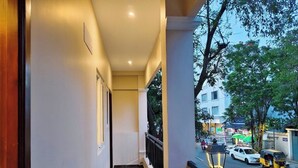 A corridor with a wooden floor, white walls, and a balcony with a railing. - Seaa Breeze (Puducherry)