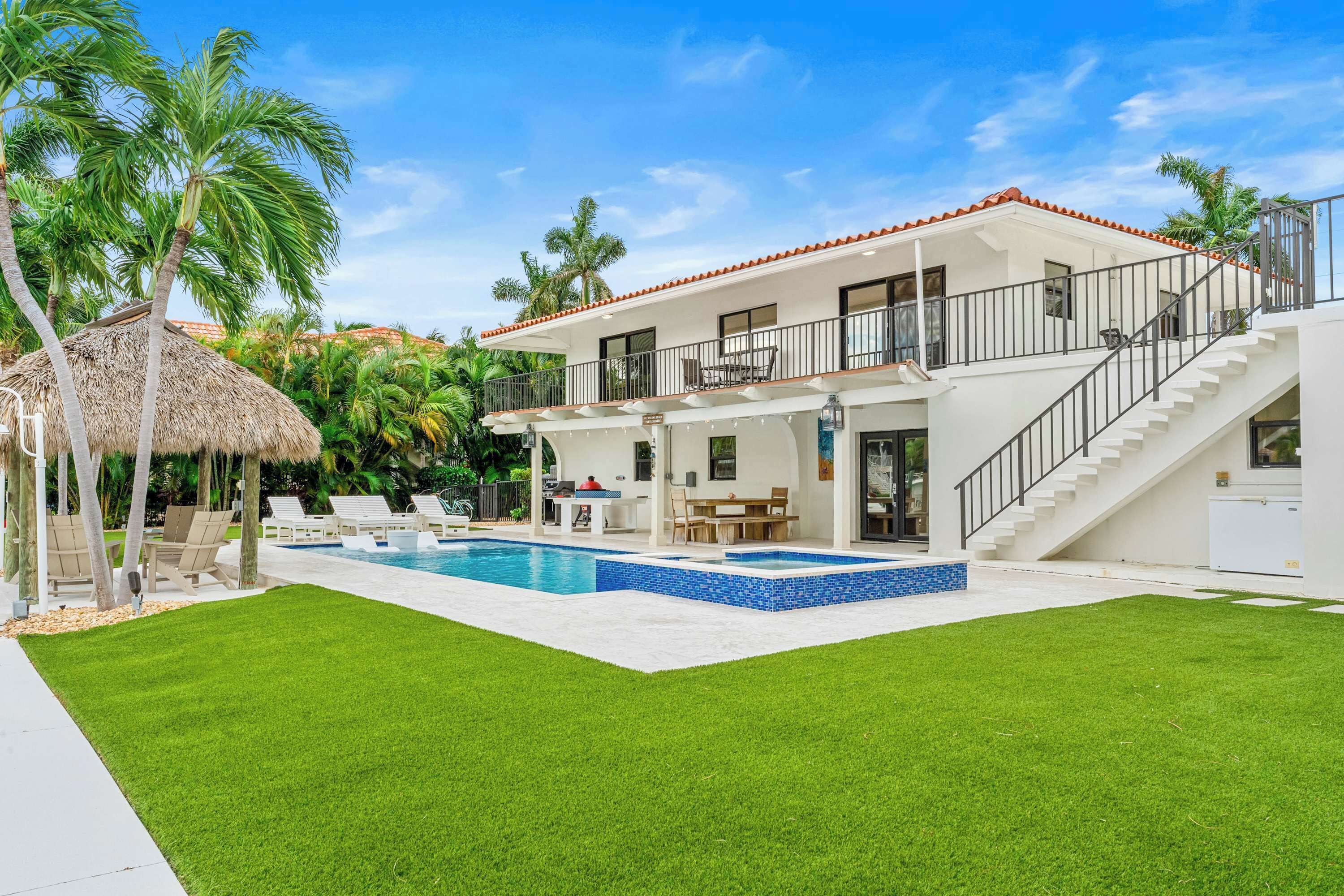 A two-story house with a swimming pool, a covered patio, and a staircase leading to the upper level.