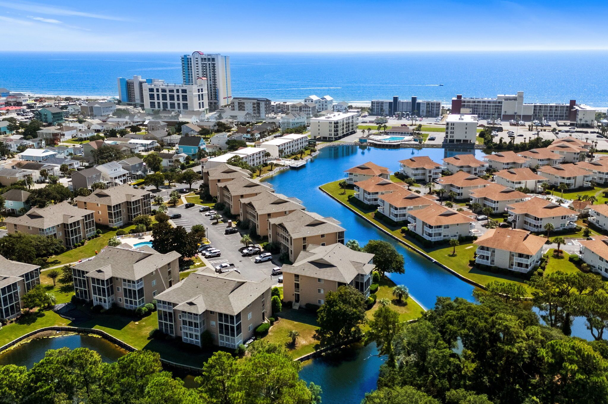 Zona residencial costera con edificios de apartamentos, un puerto deportivo y vistas al océano.