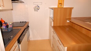 A compact kitchen with a stove, oven, and wooden countertop. - Gourette Studio 4 pers, Slope View, WIFI, Pets (Gourette)
