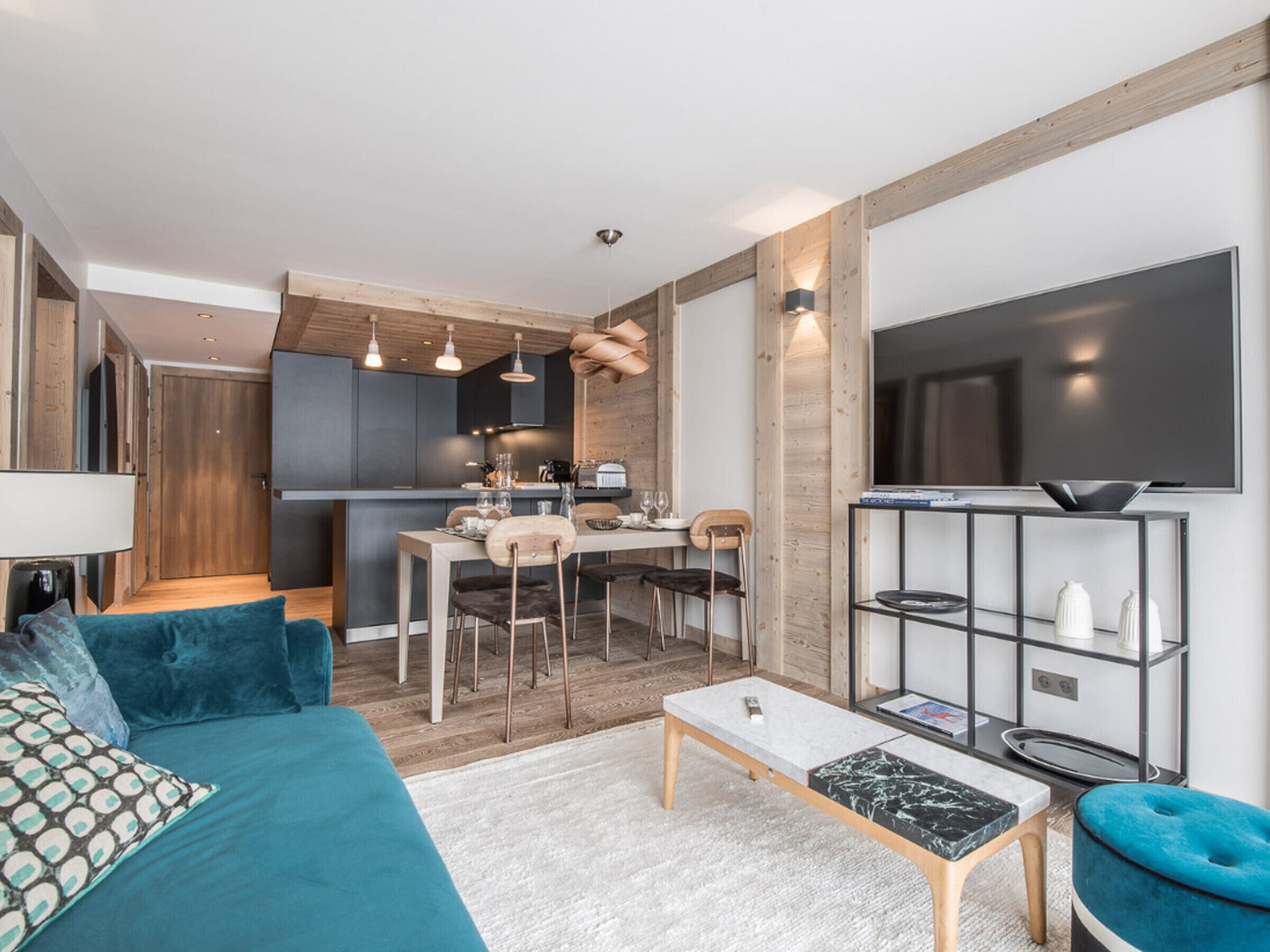 Un salon moderne avec un canapé, une table basse et un téléviseur.