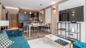 Una sala de estar moderna con sofá, mesa de centro y televisor.