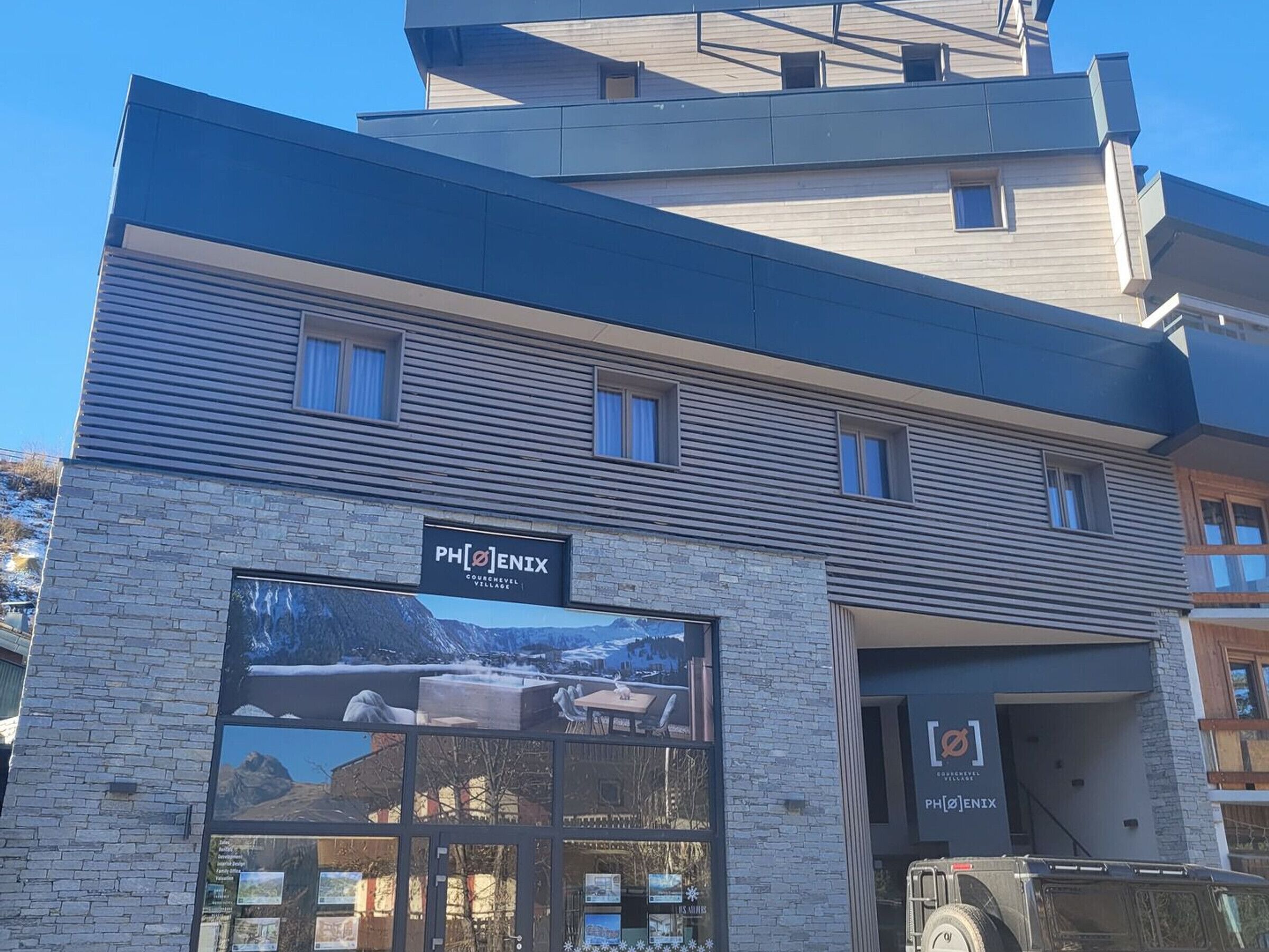 Ein modernes Gebäude mit einem Schild für PHENIX Courchevel Village.