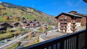 A mountain resort with chalet-style buildings, a parking area, and a view of the surrounding hills. - Cozy apt for 4, near slopes and pool (Arêches-Beaufort)