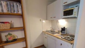 A compact kitchen with white cabinets, a microwave, a sink, and a coffee maker. - Cozy apt for 4, near slopes and pool (Arêches-Beaufort)