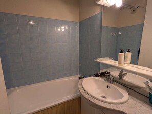 A bathroom with a bathtub, a sink, and a mirror. - Cozy apt for 4, near slopes and pool (Arêches-Beaufort)