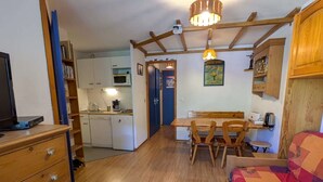 A compact living space with a kitchenette, a dining area, and a bed. - Cozy apt for 4, near slopes and pool (Arêches-Beaufort)