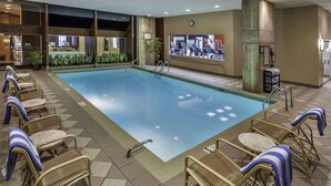 A swimming pool with lounge chairs and a treadmill.