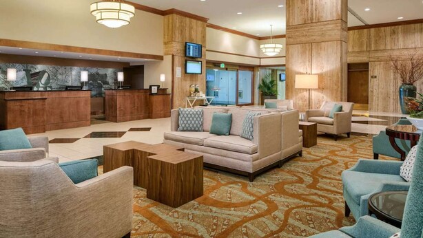 A spacious lobby with a reception desk, seating area, and a large pillar. - Close to PHL Airport + Dining. Pool. Free Shuttle. (Philadelphia)