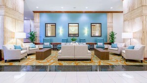 A lobby with a central seating area, two side tables, and a patterned carpet. - Close to PHL Airport + Dining. Pool. Free Shuttle. (Philadelphia)
