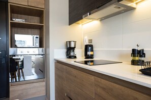 A modern kitchen with a built-in microwave, coffee maker, and kettle on the counter. - Family-friendly Apartment, Pool & Panoramic Views (Ñuñoa)