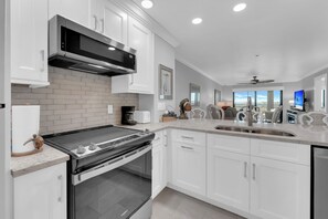 A modern kitchen with white cabinets, a stainless steel range hood, and a built-in oven. - 2B/2B HARBOUR POINTE CONDO 816S ON THE BAY, WATCH THE BOATS GO BY, FISHING DOCK, WALK TO BEACH! (Fort Myers Beach)