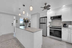 A modern kitchen with white cabinetry, stainless steel appliances, and pendant lighting. - 2B/2B HARBOUR POINTE CONDO 816S ON THE BAY, WATCH THE BOATS GO BY, FISHING DOCK, WALK TO BEACH! (Fort Myers Beach)