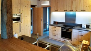 A modern kitchen with wooden cabinets, a built-in oven, a sink, and a toaster. - Charming Basque house with swimming pool (Souraïde)
