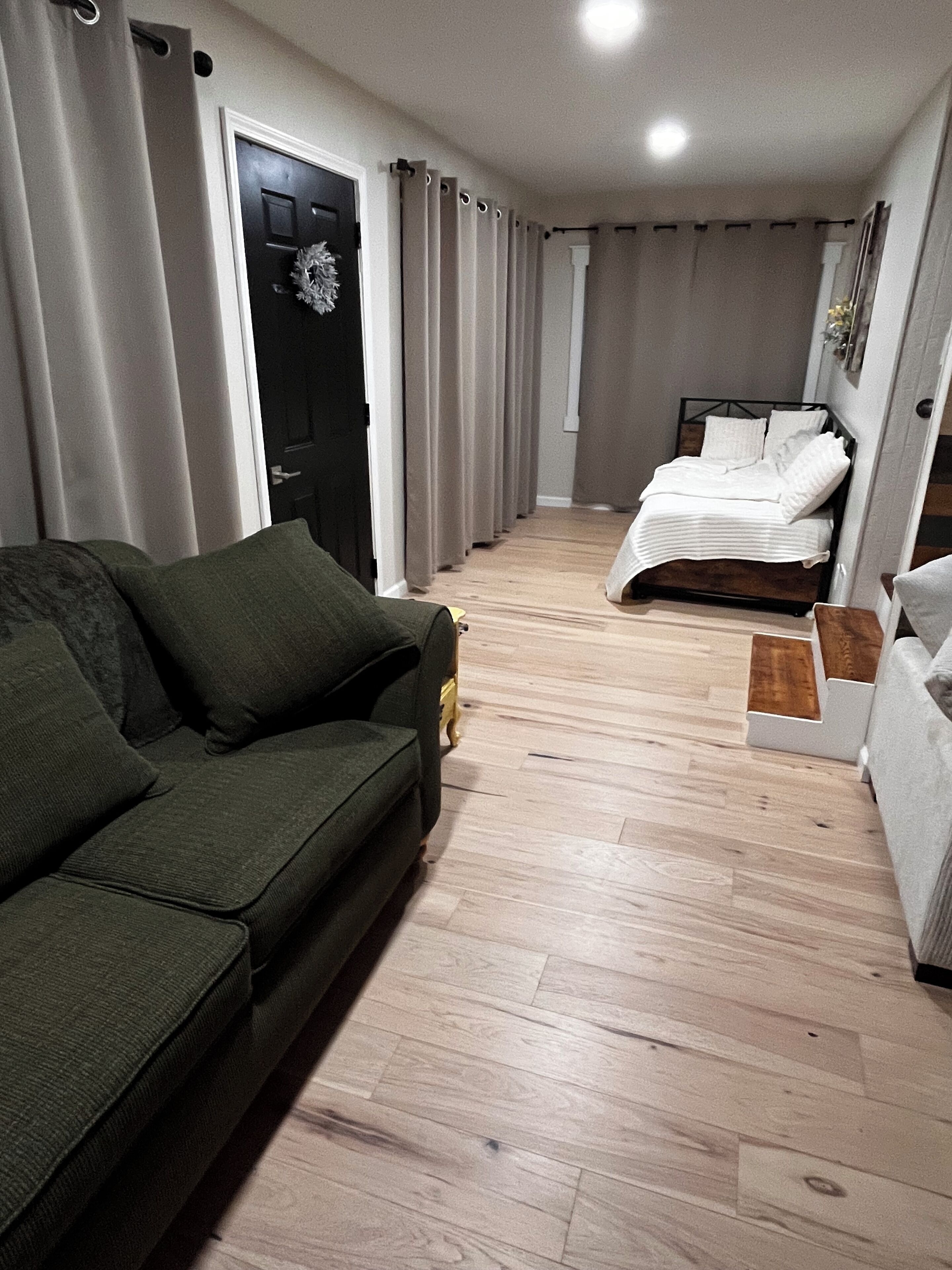 Un espace de vie compact comprenant un canapé, un lit et une petite table.