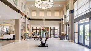 A spacious lobby with a central table, seating area, and large windows. - Landing Apartments - North Dallas (Dallas)