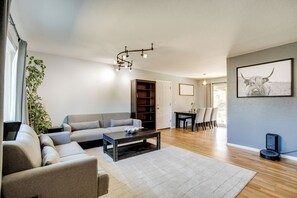 Una sala de estar moderna con un sofá, una mesa de centro y un comedor con sillas y una mesa.